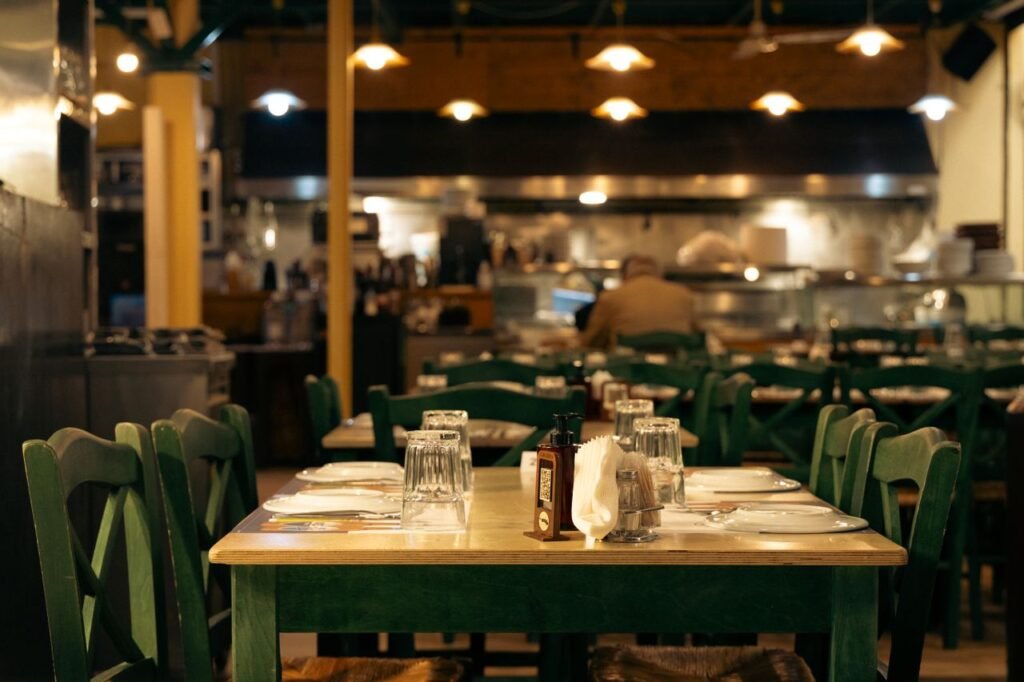 Cómo conseguir más clientes para un restaurante familiar este verano Warm and inviting Greek café interior with set dining tables in Athens, Greece.