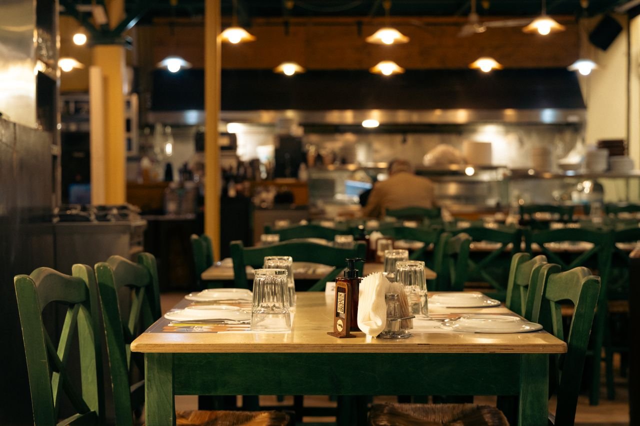 Warm and inviting Greek café interior with set dining tables in Athens, Greece.